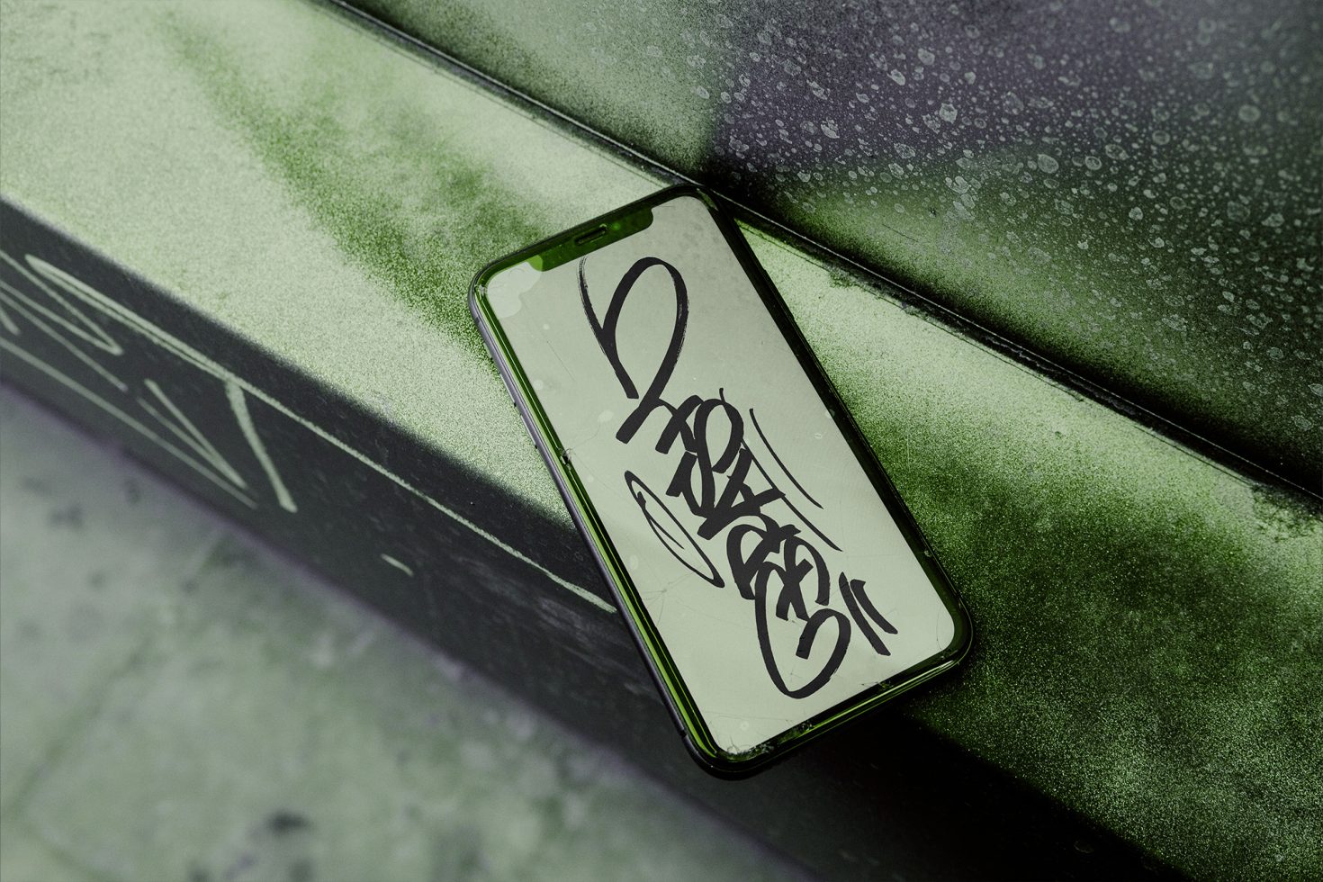 Smartphone screen mockup with urban graffiti style design on a dusty green bench, showing realistic display for digital art.